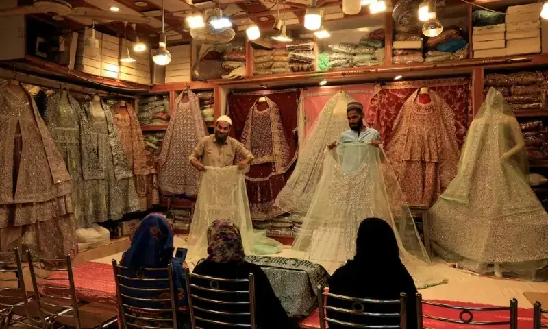 Shopkeepers display bridal dresses to customers at a shop in a cloth market in Karachi, Pakistan September 23, 2025. &mdash; Reuters/File