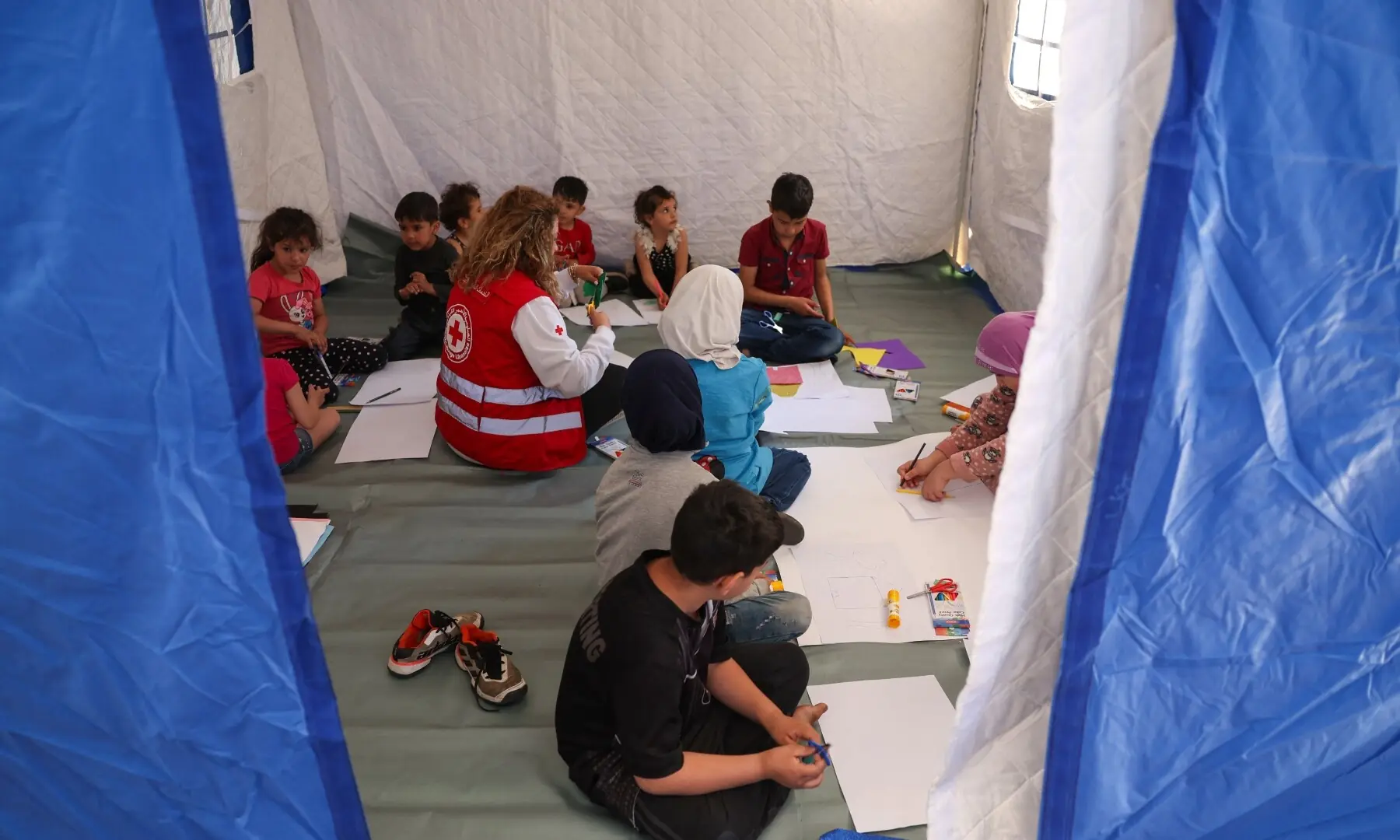 A member of the Red Cross provides learning activities to children inside a tent at Camille Chamoun Sports City stadium turned into a temporary shelter in Beirut, Lebanon on May 8, 2026. &mdash;Reuters