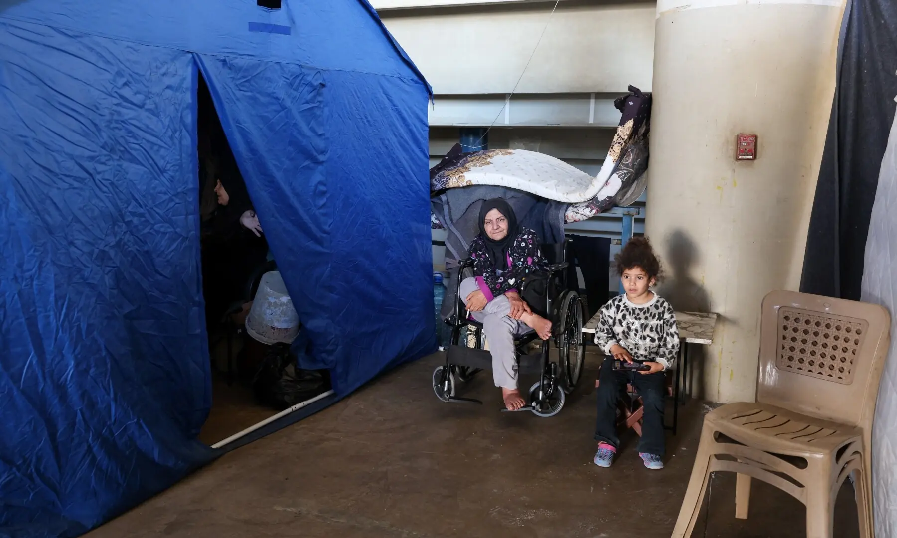 People sit outside their tent at Camille Chamoun Sports City stadium turned into a temporary shelter in Beirut, Lebanon on May 8, 2026. &mdash;Reuters