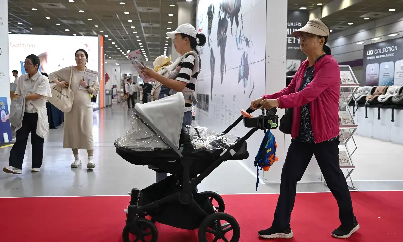 This picture taken on April 30, 2026 shows a woman pushing a stroller as she visits a baby fair in Seoul. &mdash; AFP