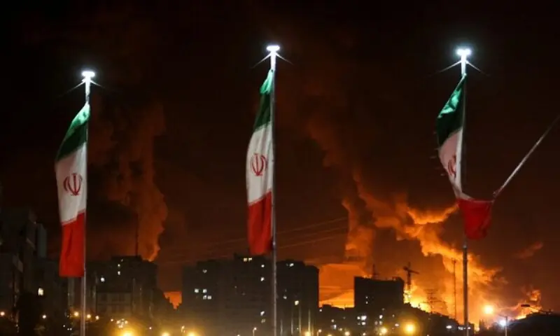 Iranian flags fly as fire and smoke from an Israeli attack on Sharan Oil depot rise, following Israeli strikes on Iran, in Tehran, Iran, June 15, 2025. &mdash;Reuters/File