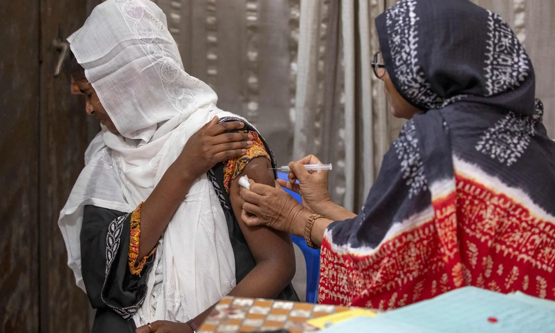This photograph taken on April 27, 2026 shows Tahmina (R), a family welfare officer admistering a birth control injection to a woman at the Savar Upazila Health Complex in Dhaka. &mdash;AFP