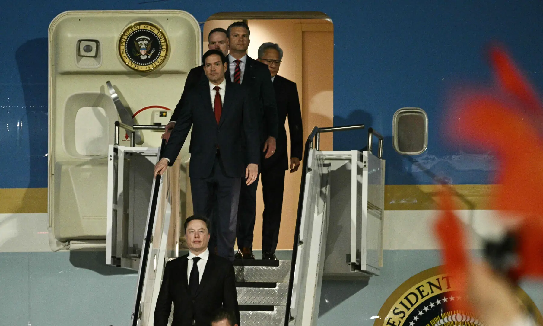Tesla CEO Elon Musk (C), US Secretary of State Marco Rubio, US Secretary of Defence Pete Hegseth and Nvidia founder and CEO Jensen Huang walk off Air Force One upon arriving at Beijing Capital Airport in Beijing on May 13, 2026. &mdash; AFP