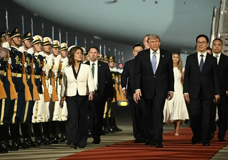 US President Donald Trump (C) is escorted by China's Vice President Han Zheng (R) upon his arrival at Beijing Capital Airport in Beijing on May 13, 2026. &mdash; AFP