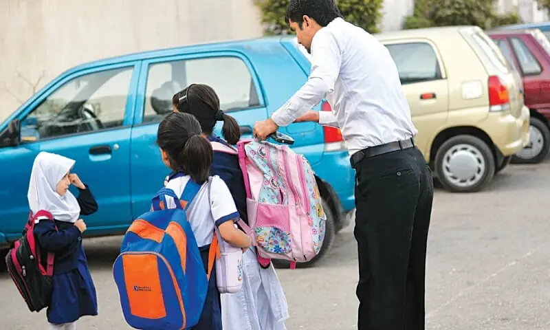 In this file photo, a man drops off his kids at school in Karachi. — White Star In this file photo, a man drops off his kids at school in Karachi. — White Star
