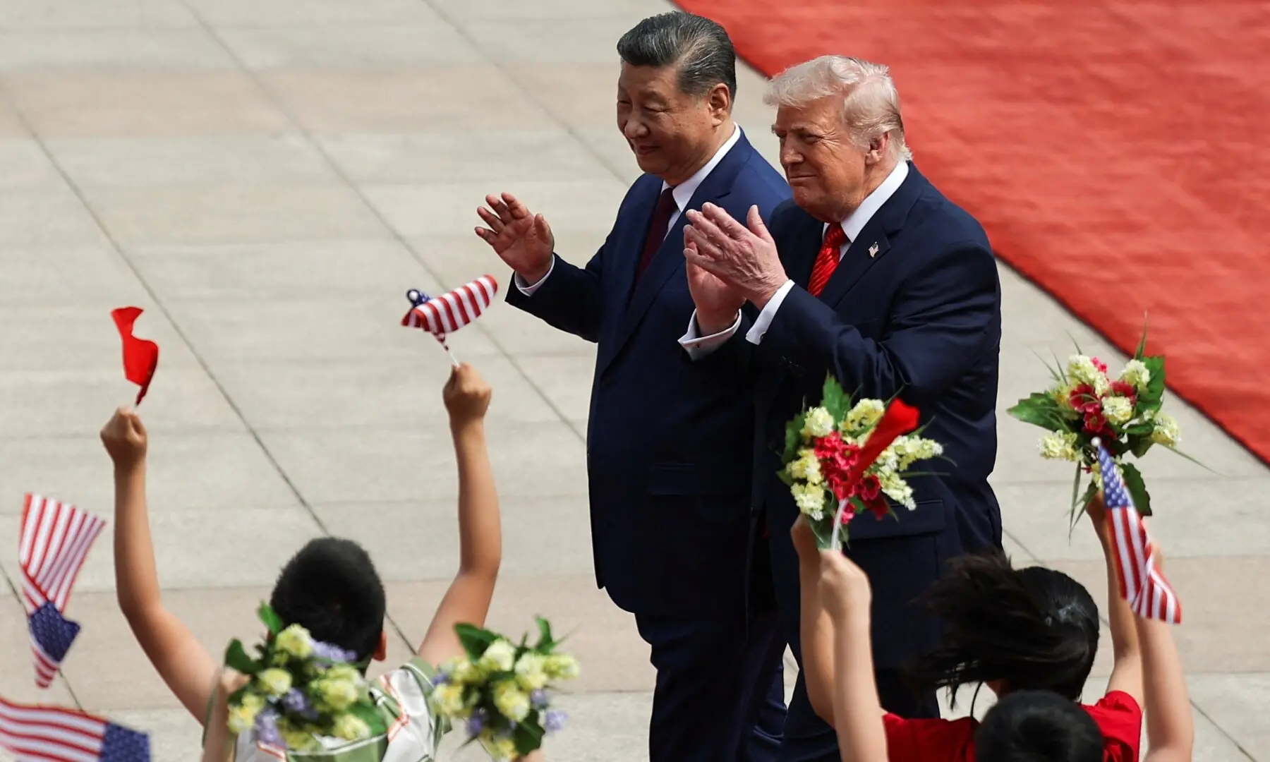 Chinese President Xi Jinping and US President Donald Trump react near children during a welcome ceremony at the Great Hall of the People, in Beijing, China, May 14, 2026. &mdash;Reuters