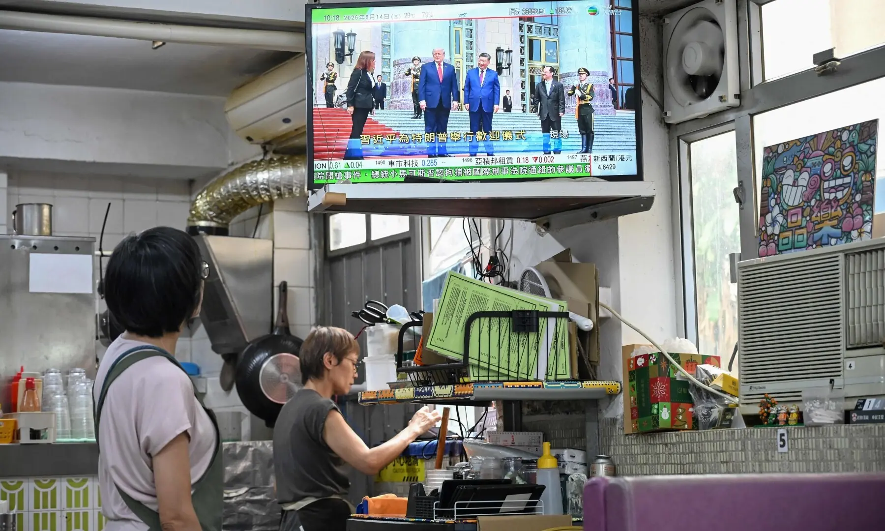 A television news programme at a restaurant in Hong Kong on May 14, 2026 shows the meeting between the US President Donald Trump and China&rsquo;s President Xi Jinping in Beijing. &mdash;AFP