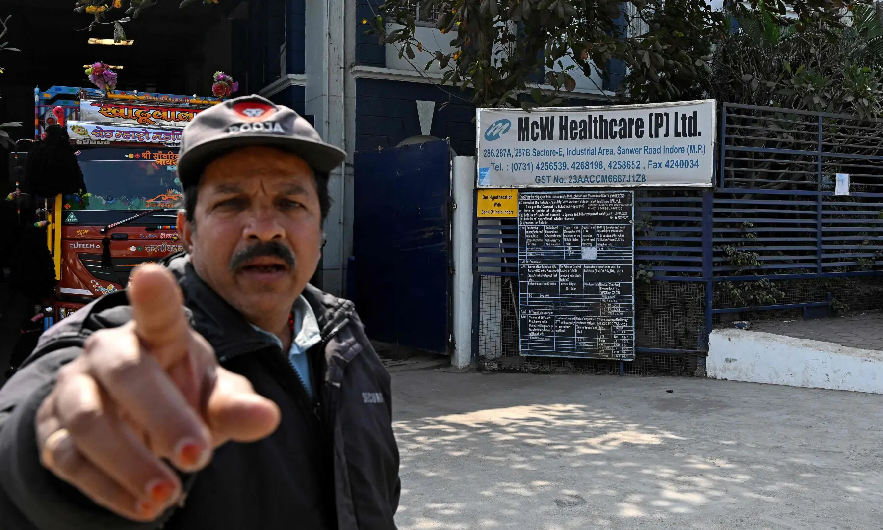 This photograph taken on January 19, 2026 shows a security guard pointing to a camera outside Indian pharmaceutical firm McW Healthcare’s manufacturing plant in Indore. — AFP