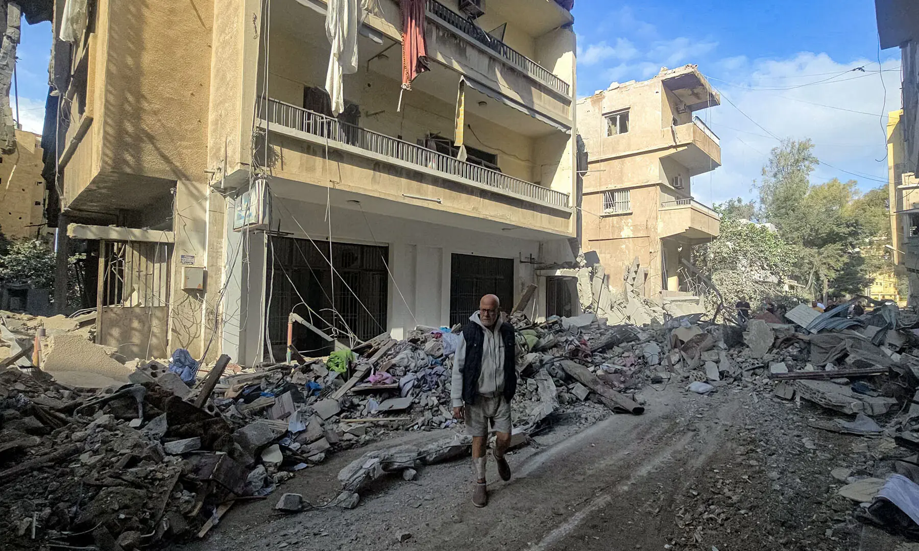 People stand by rubble and debris near damaged and collapsed buildings following overnight Israeli bombardment on Lebanon&rsquo;s southern city of Tyre on May 16, 2026. &mdash; AFP