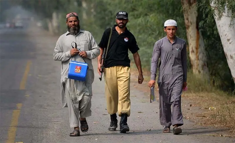 In this file photo, a policemen accompanies polio workers on an immunisation campaign. — Reuters/File In this file photo, a policemen accompanies polio workers on an immunisation campaign. — Reuters/File