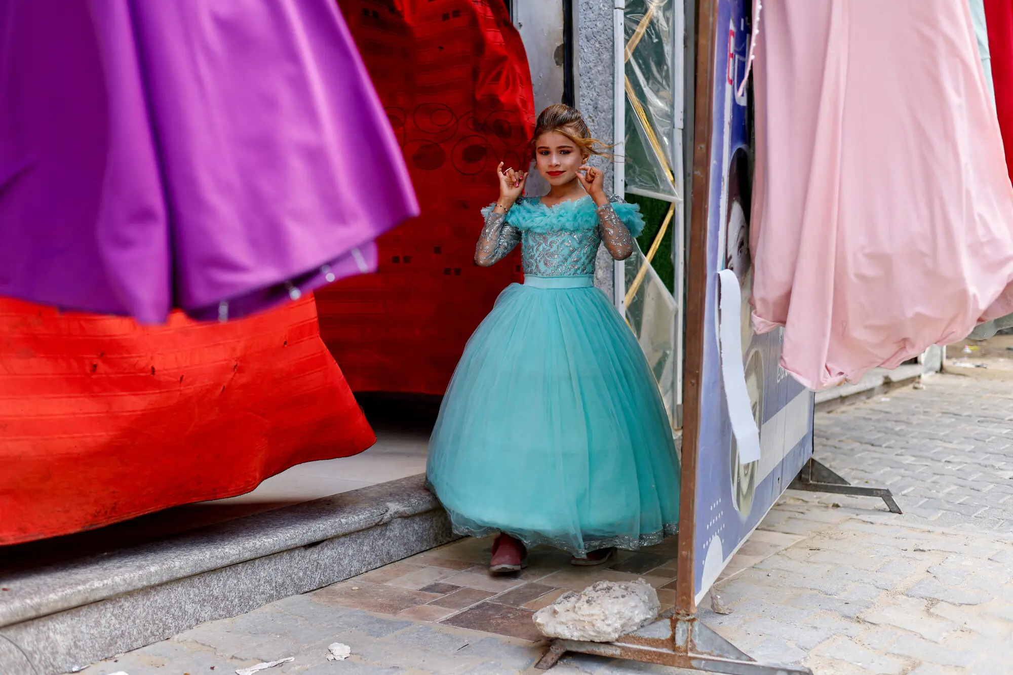 A little girl tries on a refurbished dress