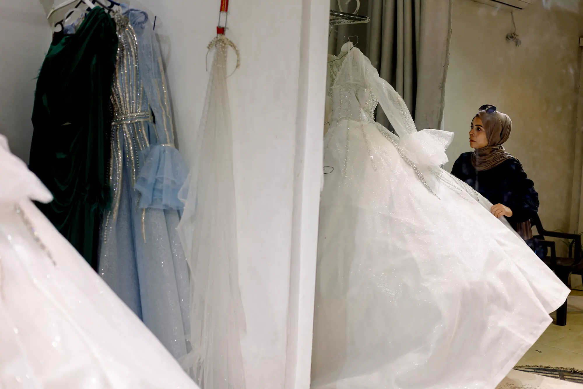 A woman checks a bridal dress in Gaza.