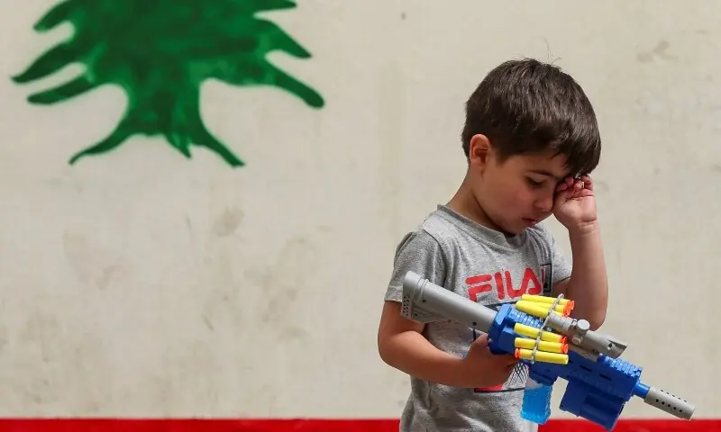 A boy, displaced from southern Lebanon amid the conflict with Israel, holds a toy gun as he walks at a school-turned shelter, near Sidon, Lebanon, May 17, 2026. &mdash;Reuters