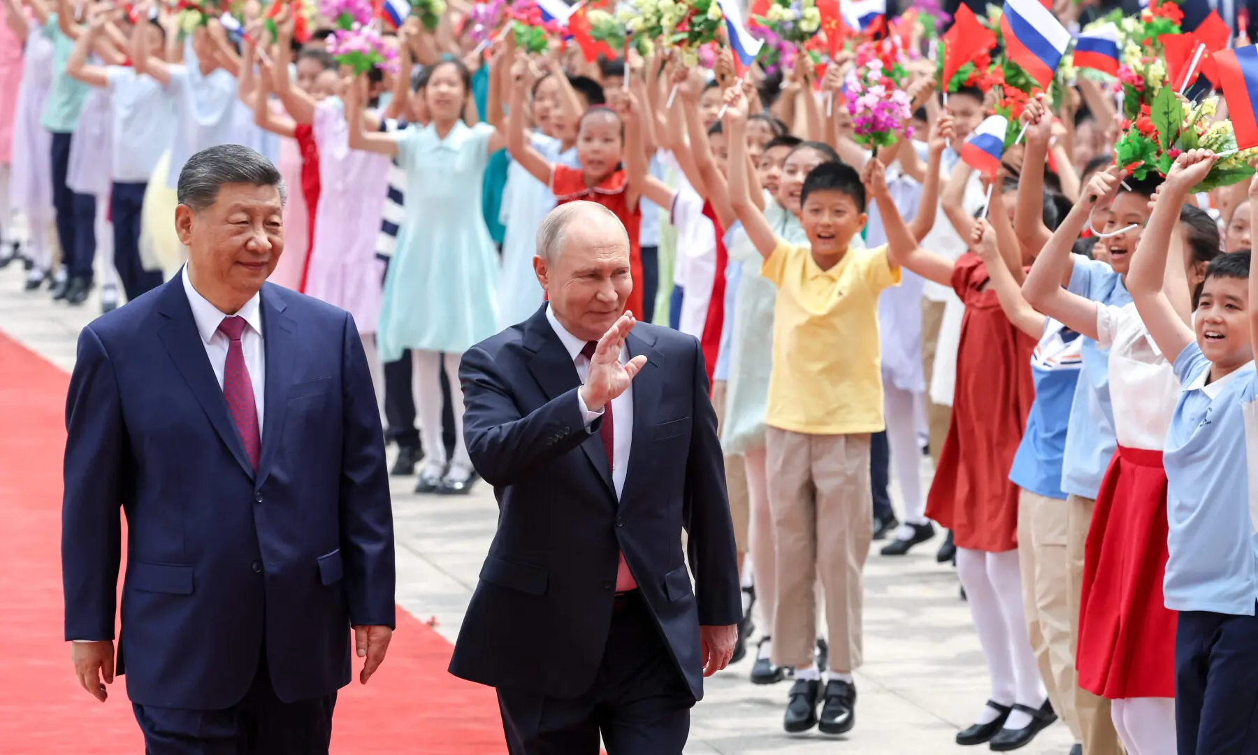 In this pool photograph distributed by the Russian state agency Sputnik, Russia's President Vladimir Putin (L) and China's President Xi Jinping take part in a welcome ceremony at the Great Hall of the People in Beijing on May 20, 2026. &mdash; AFP