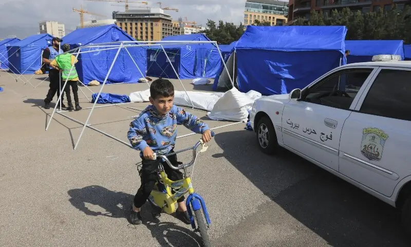 A child plays next to people setting up tents at the Beirut waterfront, in Beirut, Lebanon, May 21, 2026. &mdash;Reuters