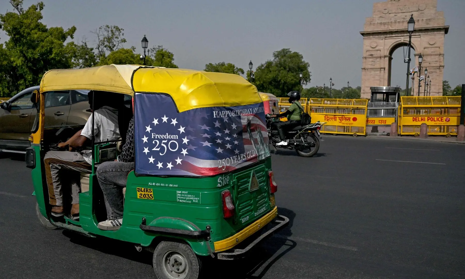 An autorickshaw with a poster marking the 250th anniversary of American independence, moves past the India Gate in New Delhi on May 21, 2026. — AFP