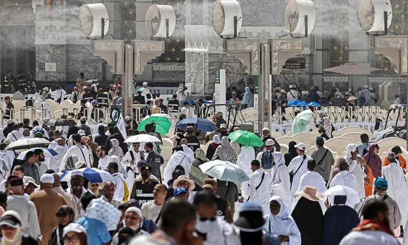WORSHIPPERS walk under water-mist fans along the Grand Mosque complex in Makkah.&mdash;AFP