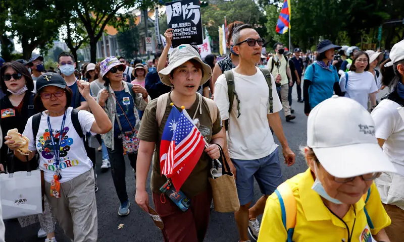 A person holds a Taiwan and US flag at a rally in Taipei to support government plans to increase defence spending.&mdash;Reuters