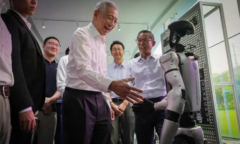 Singapore&rsquo;s Senior Minister Lee Hsien Loong shakes hands with a robot as he tours the Shanghai Municipal Humanoid Robot Innovation Incubator. &mdash;Courtesy The Straits Times