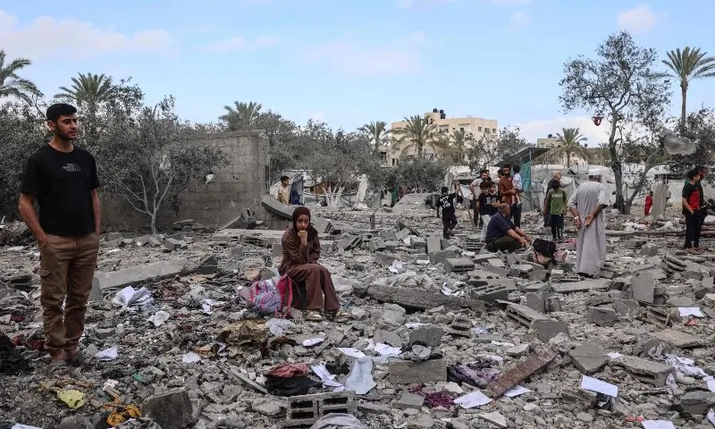 Palestinians look at the damage at the site of a residential building targeted overnight by an Israeli strike, following a warning from the Israeli military to evacuate, in Deir el-Balah in the central Gaza Strip, on May 24, 2026. &mdash; AFP