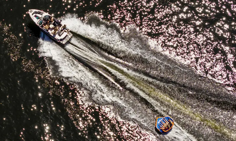 This aerial photograph shows people being pulled on an inflatable by a motorboat on Lake Gooimeer during a heatwave in Muiden, the Netherlands, on May 25, 2026. - AFP