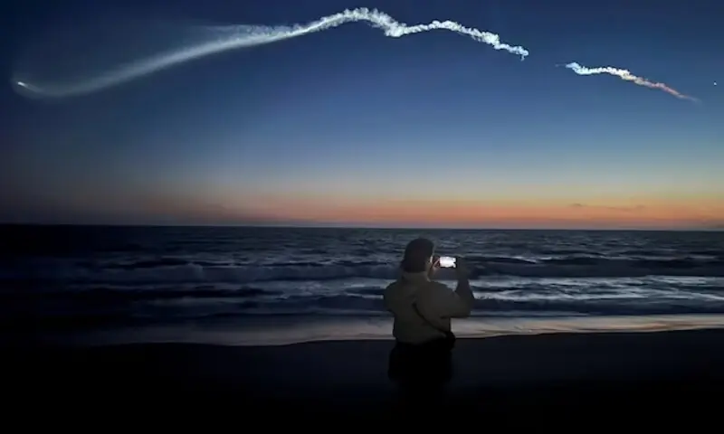 A person takes photos of a trail as the Falcon 9 carrying Starlink satellites streaks across the sky in the latest SpaceX launch as viewed from Venice Beach in Los Angeles, California, the US on April 6, 2026. &mdash; Reuters/File