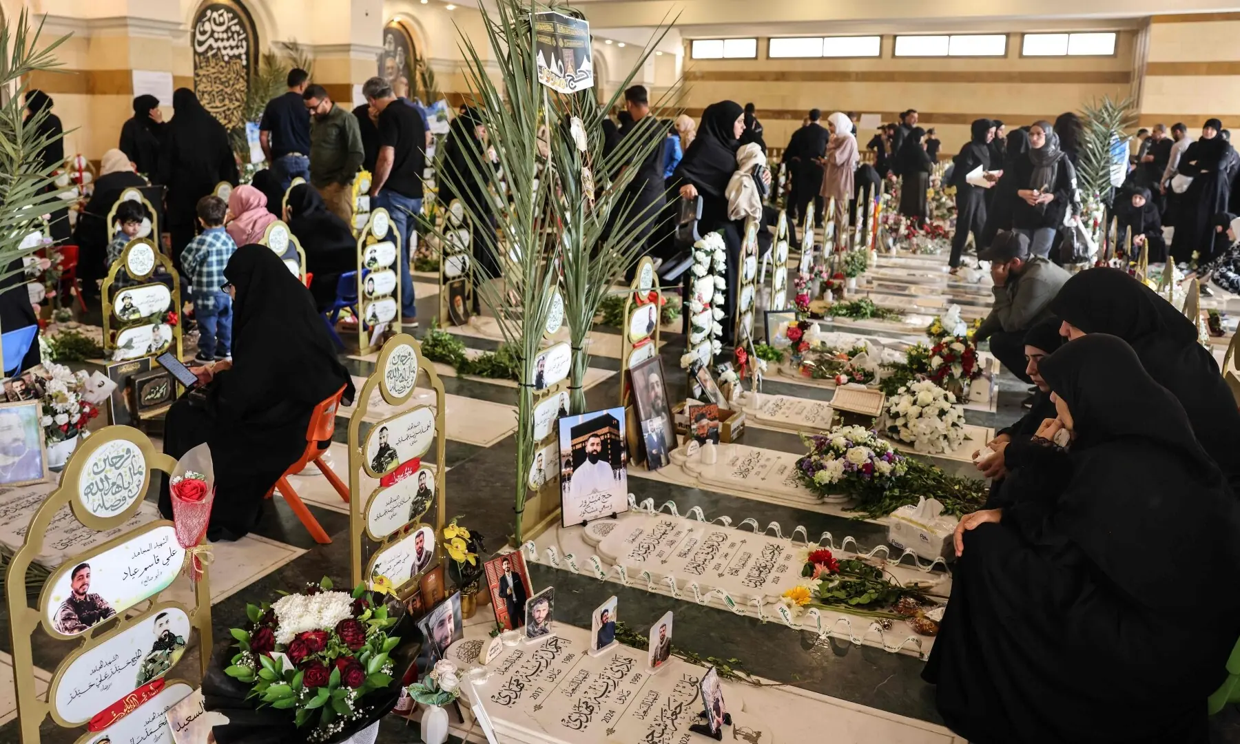  Families of Hezbollah fighters killed in the conflict visit the graves of their relatives on the morning of Eid al-Adha, the Feast of Sacrifice, at the Hawra Zaynab cemetery in Beirut’s southern suburbs on May 27. — AFP 