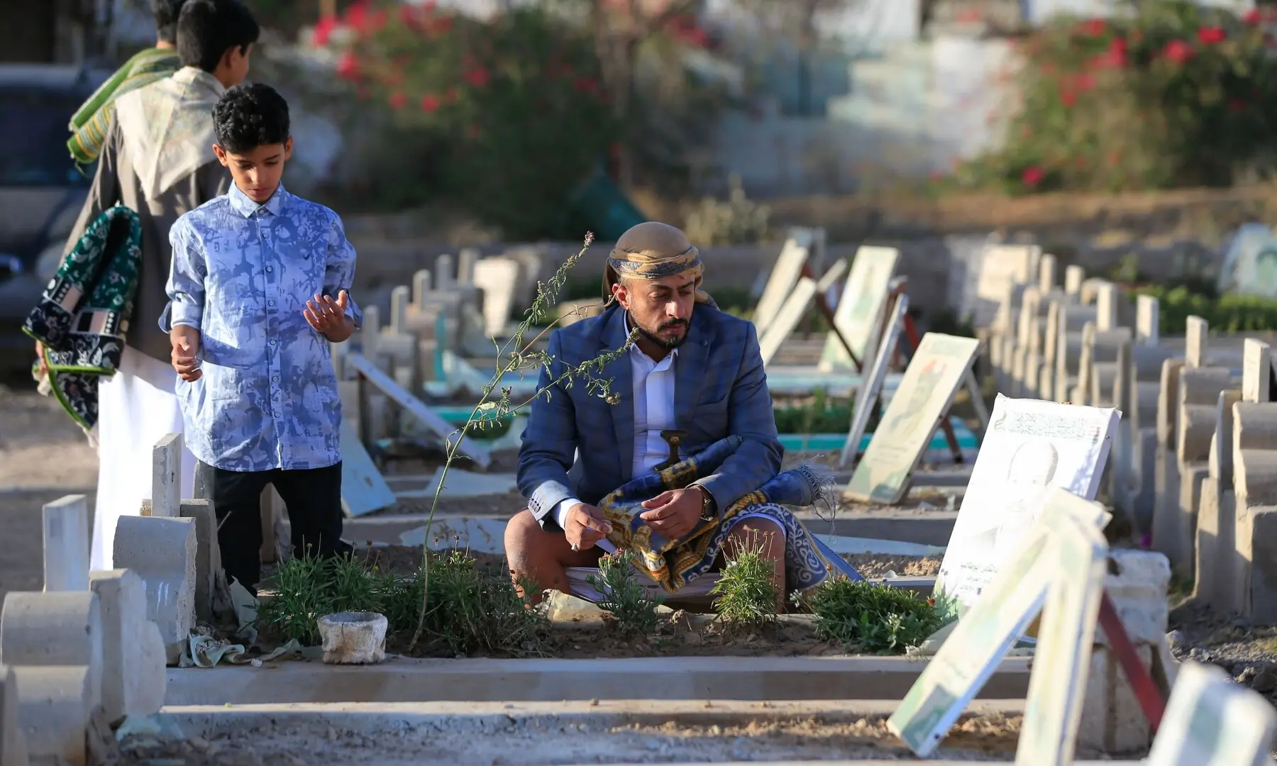 Yemenis visit a graveyard on the first day of Eid al-Adha, the Feast of Sacrifice, in Sanaa on May 27. — Reuters