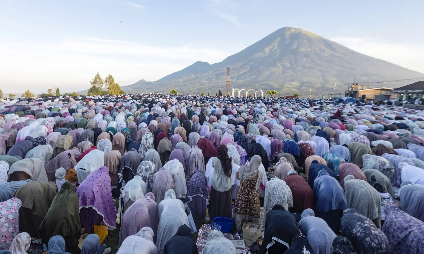 Indonesian Muslim women offer Eid al-Adha mass prayers on a field, with Mount Sindoro in the background, in Butuh village, Wonosobo, Central Java province, Indonesia, May 27. — Reuters