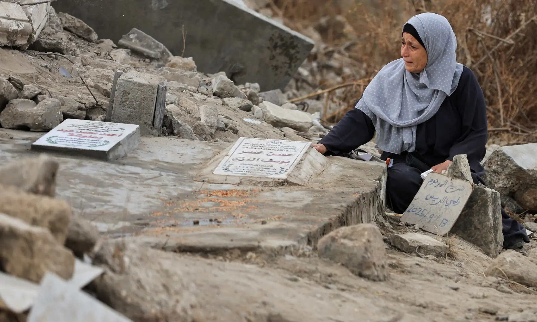 A Palestinian woman reacts as she visits a grave at a cemetery on Eid al-Adha, in Gaza City, May 27. — Reuters