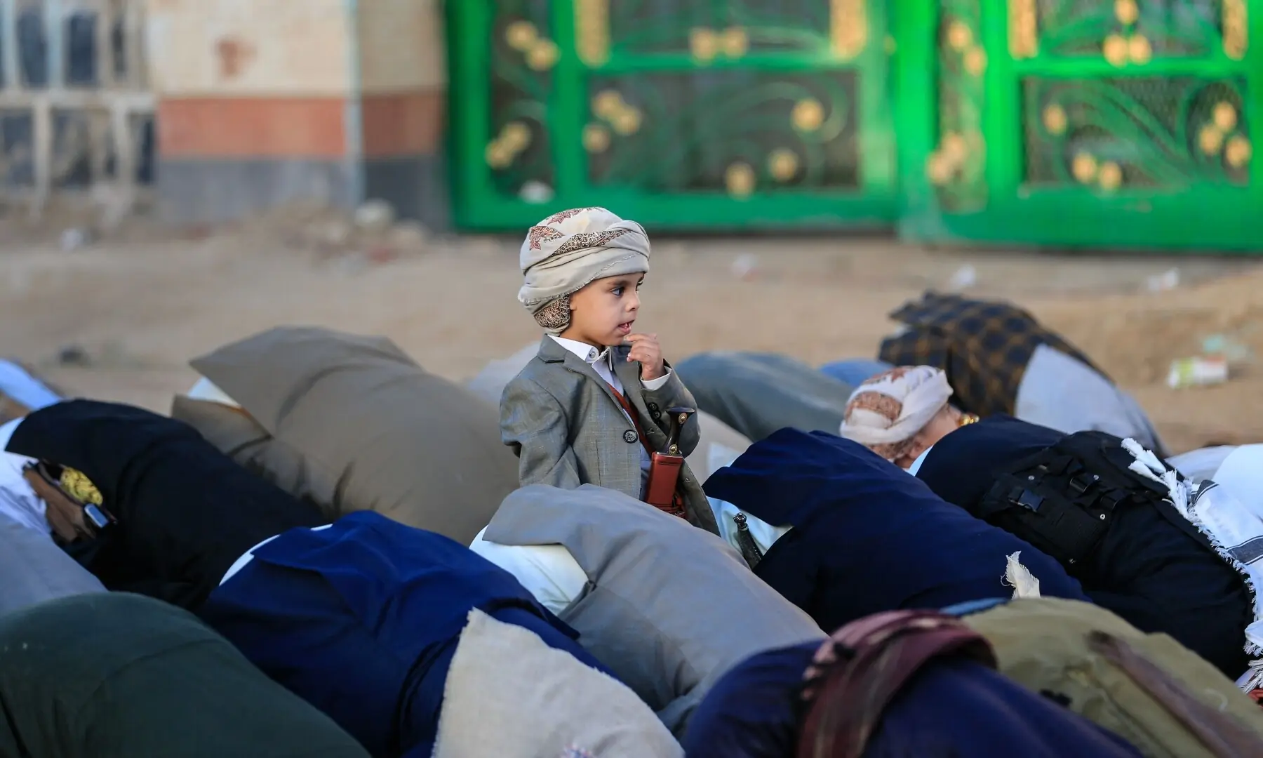 A child looks on as Yemenis perform morning prayers marking the start of Eid al-Adha, the Feast of Sacrifice, in Sanaa on May 27. — AFP