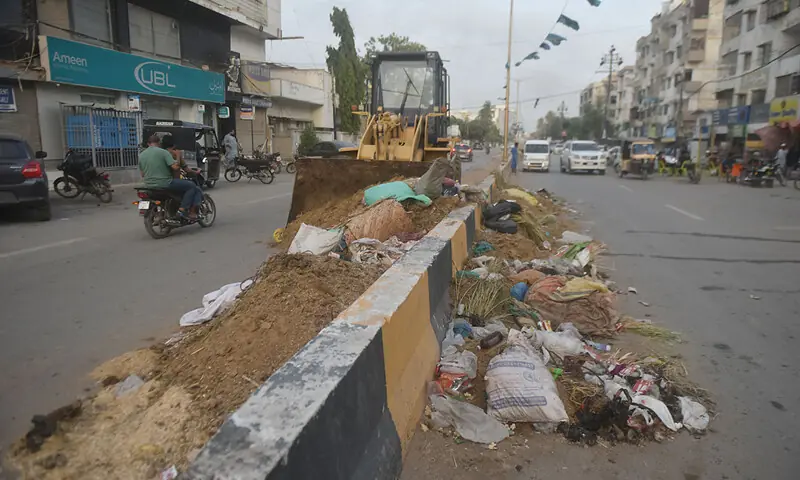 Heavy machinery is used to lift offal and garbage dumped on the roadside in a North Nazimabad area on Friday.—White Star Heavy machinery is used to lift offal and garbage dumped on the roadside in a North Nazimabad area on Friday.—White Star