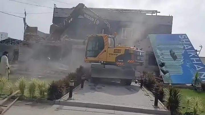 Heavy machinery is used to dismantle illegal construction on railways land in the city.&mdash;Dawn