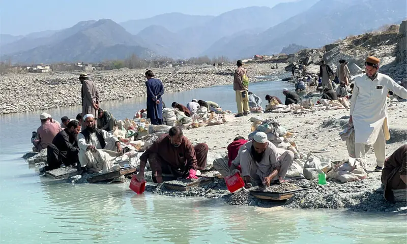 Poverty-stricken people searching for emeralds on the bank of the Swat River. &mdash; Dawn