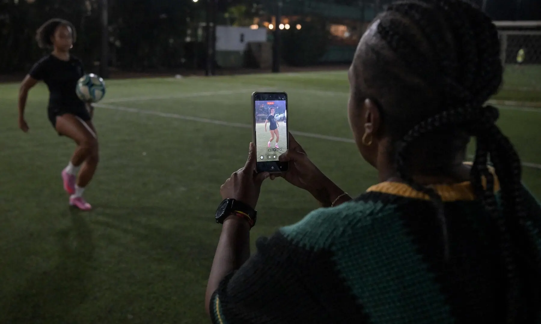 Brazilian football player Gloria Gasparini controls the ball while her mother records her for the Foot Bao app, in Sao Paulo, Brazil, on May 5, 2026. &mdash;AFP