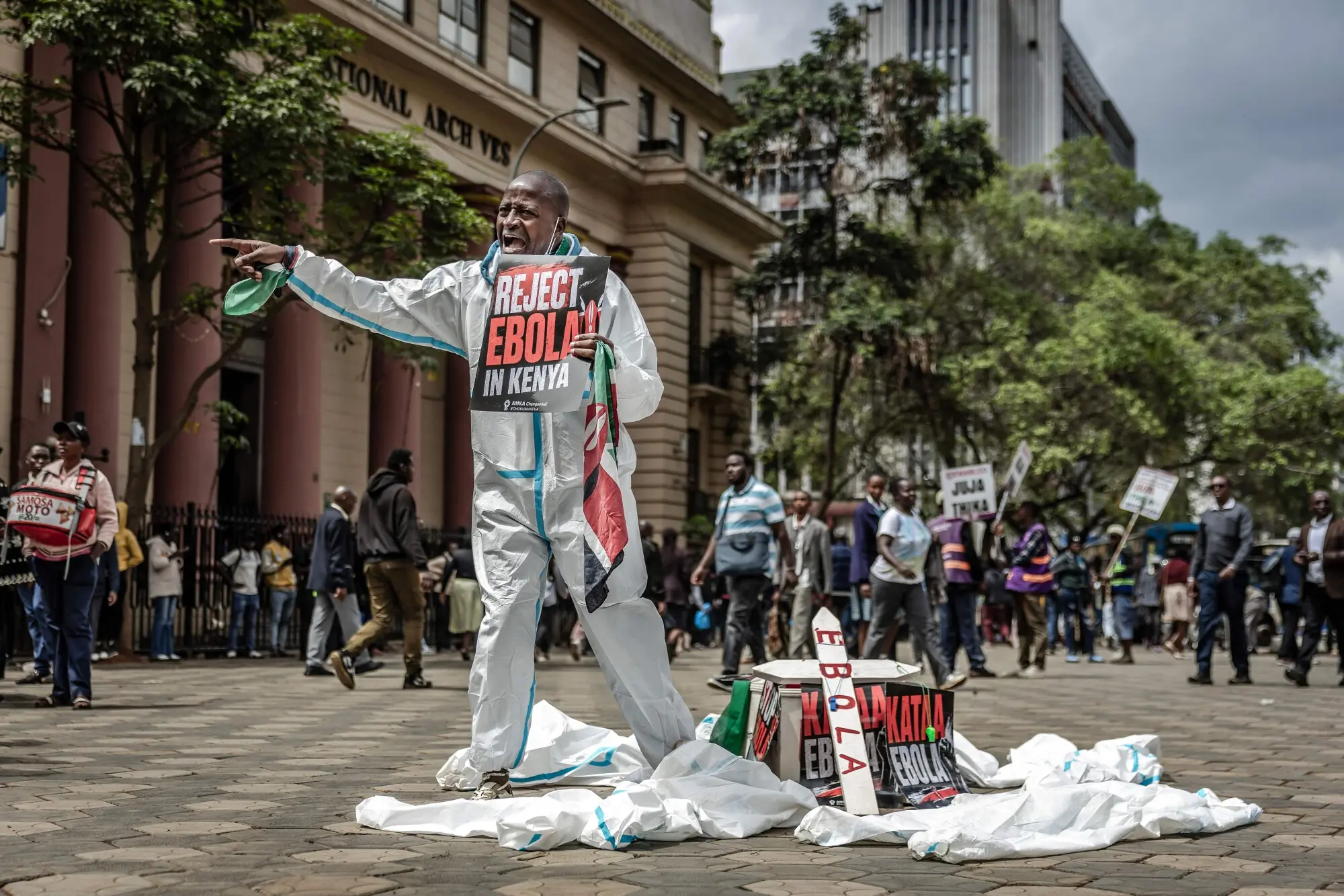 An activist shouts slogans at passers-by next to a mock coffin during a protest against a US-built Ebola quarantine centre planned to begin operations at Kenya's Laikipia Air Base, in downtown Nairobi on June 2, 2026. &mdash; AFP