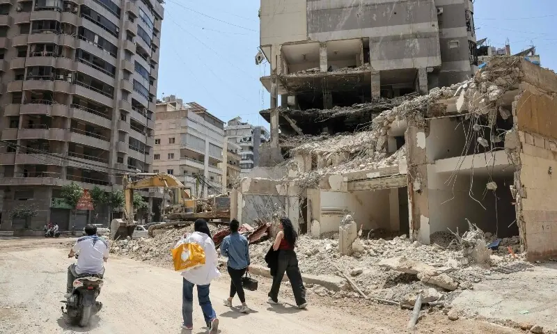  People walk past a destroyed building at a neighbourhood in Beirut&rsquo;s southern suburbs on June 2, 2026. &mdash;Reuters 