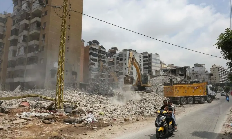  People ride a motorbike past a destroyed building at a neighbourhood in Beirut&rsquo;s southern suburbs on June 2, 2026. &mdash;AFP 
