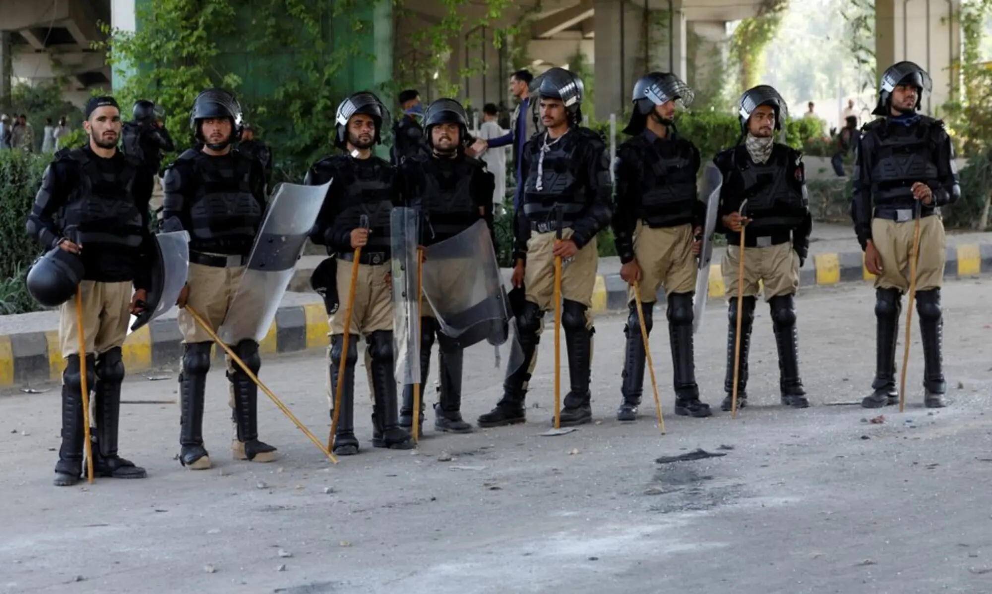 Police officer in riot gear stand guard outside a Radio Pakistan office building after it was set afire by the supporters of former prime minister Imran Khan during a protest against his arrest, in Peshawar on May 11, 2023. &mdash; Reuters