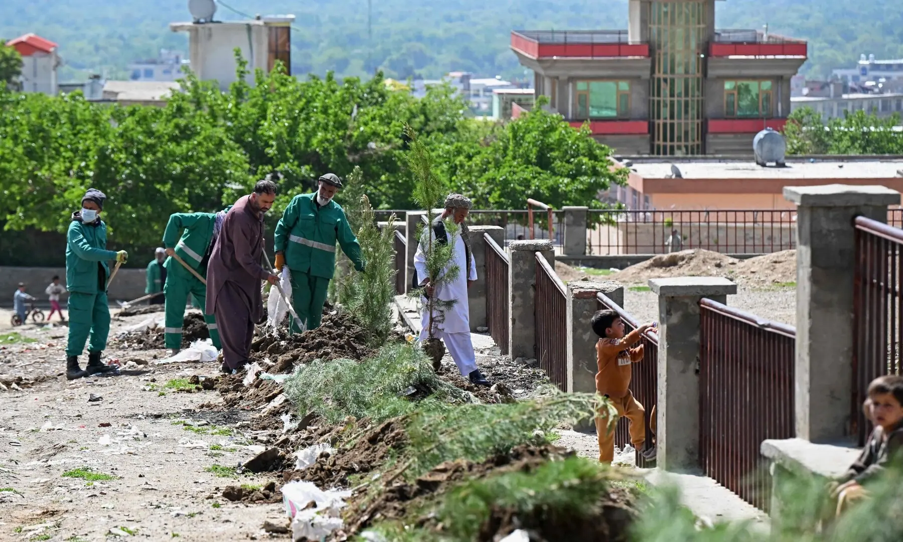This photograph taken on April 20, 2026 shows Afghan municipality workers and residents planting trees next to a park in Charikar district, Parwan province. —AFP