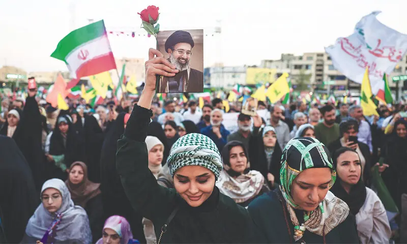TEHRAN: A woman holds an image of Mojtaba Khamenei during a rally.&mdash;Reuters