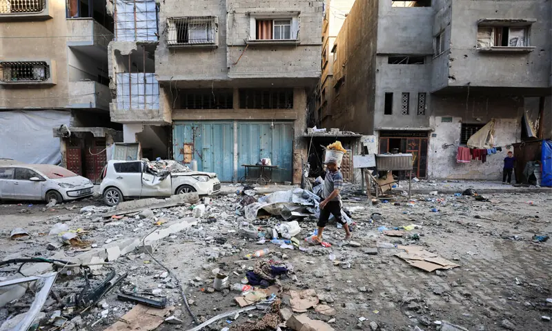 A Palestinian man walks at the site of an Israeli strike on an apartment in Gaza City.&mdash;Reuters