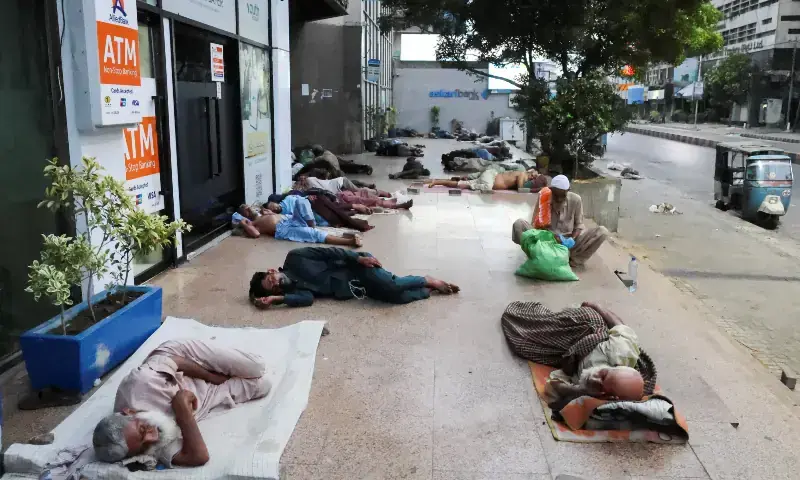 People sleep outside a business office building to escape the heat on a hot summer morning in Karachi, on May 30, 2026. &mdash; Reuters