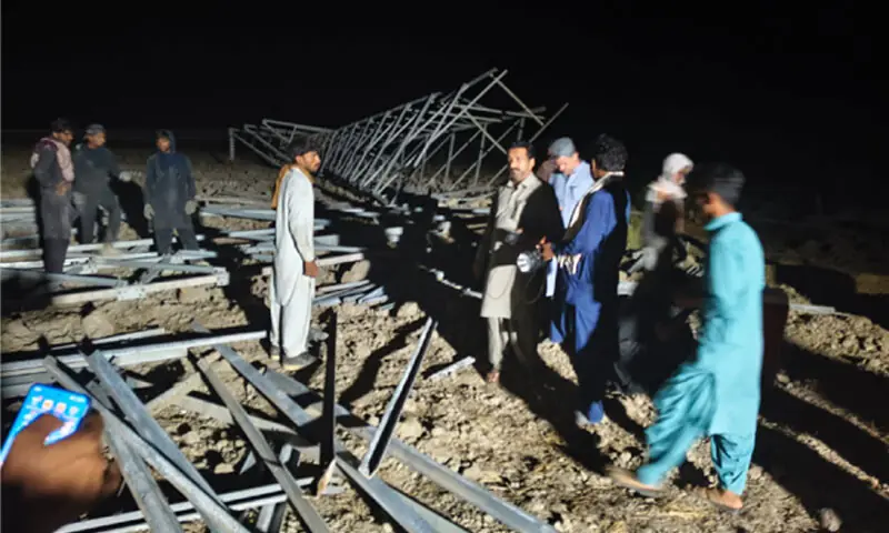 SEPCO staff busy restoring a pylon brought down by stormy winds in Larkana.&mdash;Dawn