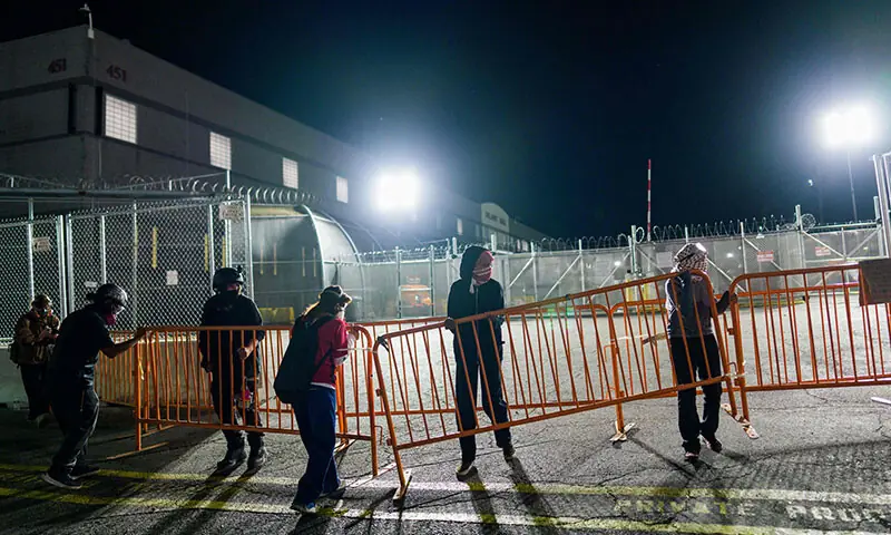 NEWARK: Protesters use barriers to block a driveway at an immigration detention centre in the US state of New Jersey. The mayor of Newark ordered police on Thursday to scale back their operation against immigrants.&mdash;AFP