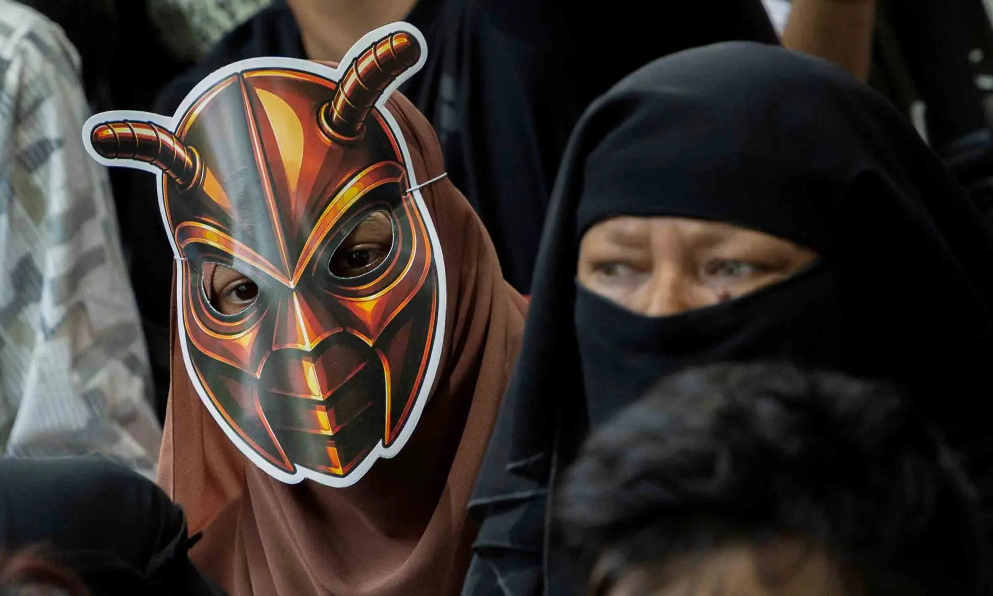 A girl wears a cockroach themed mask, as supporters of the Cockroach Janta Party (CJP) listens to Abhijeet Dipke, head of the CJP, during a sit-in protest demanding the resignation of Indian Education Minister Dharmendra Pradhan, in New Delhi, India, June 6, 2026. REUTERS/Adnan Abidi