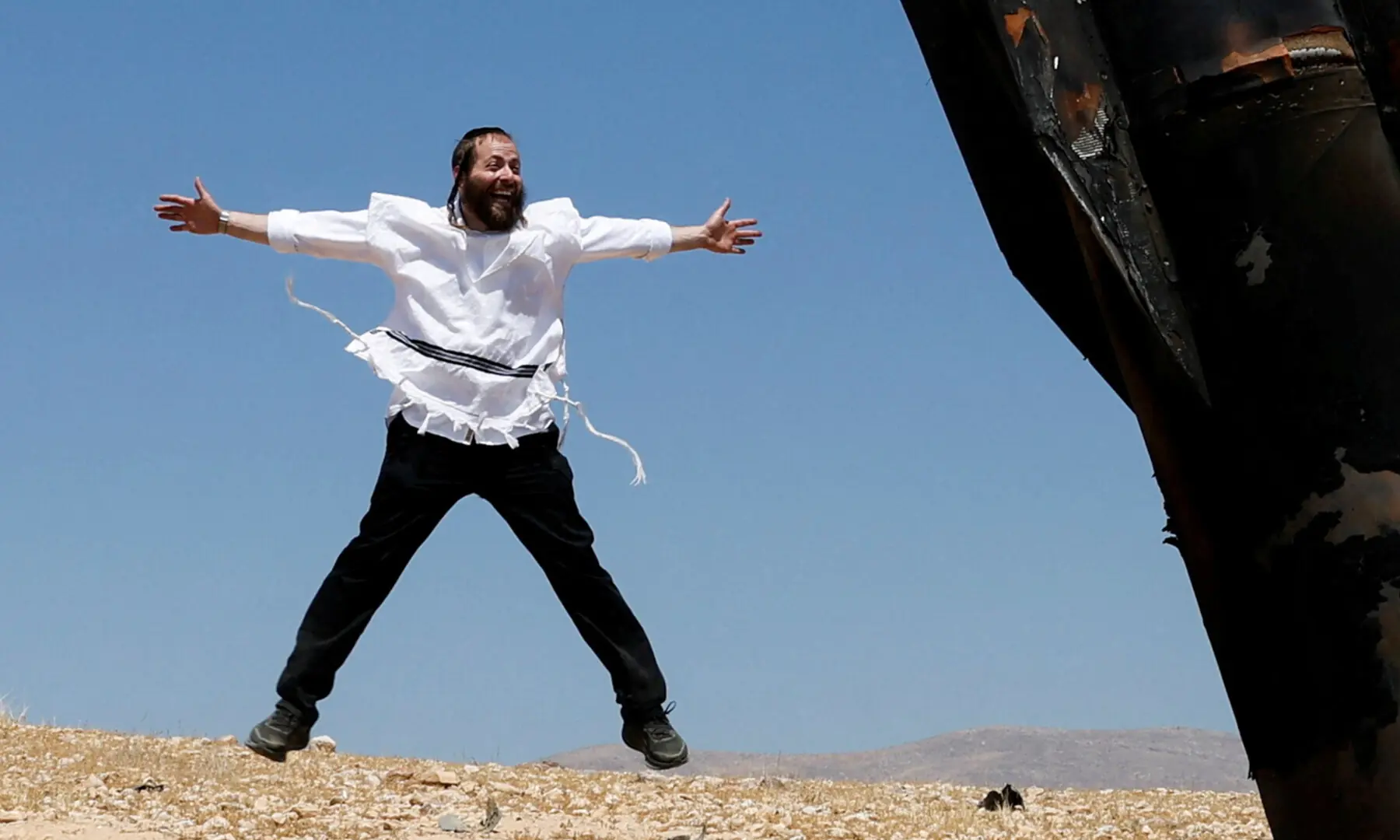  An Israeli ultra-Orthodox Jewish man reacts near a part of a missile protruding from the ground, following strikes from Iran, in the central Israeli-occupied West Bank on June 8, 2026. &mdash; Reuters 