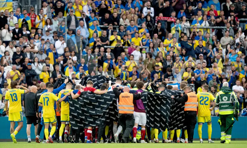 ODENSE: Players of Denmark and Ukraine huddle to accompany Christian Eriksen to a waiting ambulance during their international friendly at the Odense Stadium.—AFP ODENSE: Players of Denmark and Ukraine huddle to accompany Christian Eriksen to a waiting ambulance during their international friendly at the Odense Stadium.—AFP
