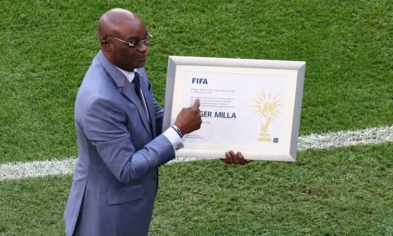 Former Cameroon player Roger Milla holds an award on the pitch before the match between Switzerland and Cameroon at the Al Janoub Stadium in Al Wakrah, Qatar on November 24, 2022. &mdash; Reuters/File