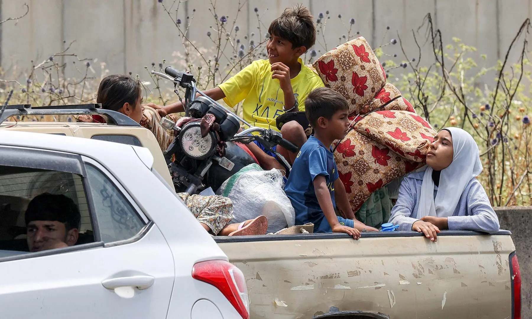 Children sit in the bed of a pickup truck waiting in traffic, as people fleeing from Tyre in southern Lebanon after Israel&rsquo;s evacuation warning seek refuge in more northerly Sidon on June 9, 2026. &mdash; AFP